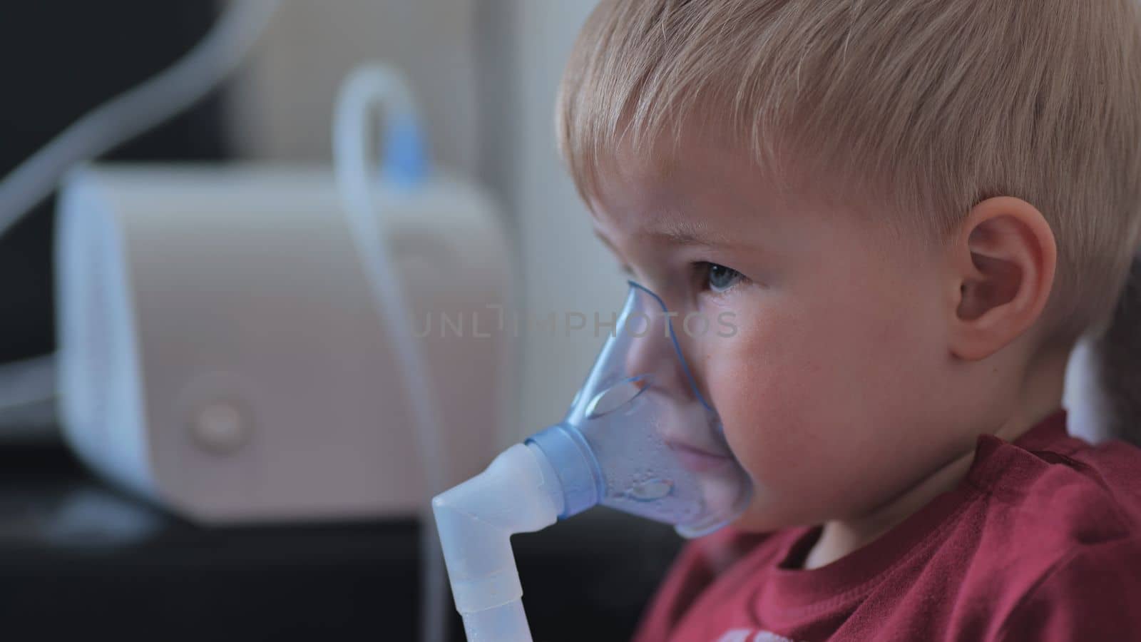 Funny boy breathing through an inhaler mask