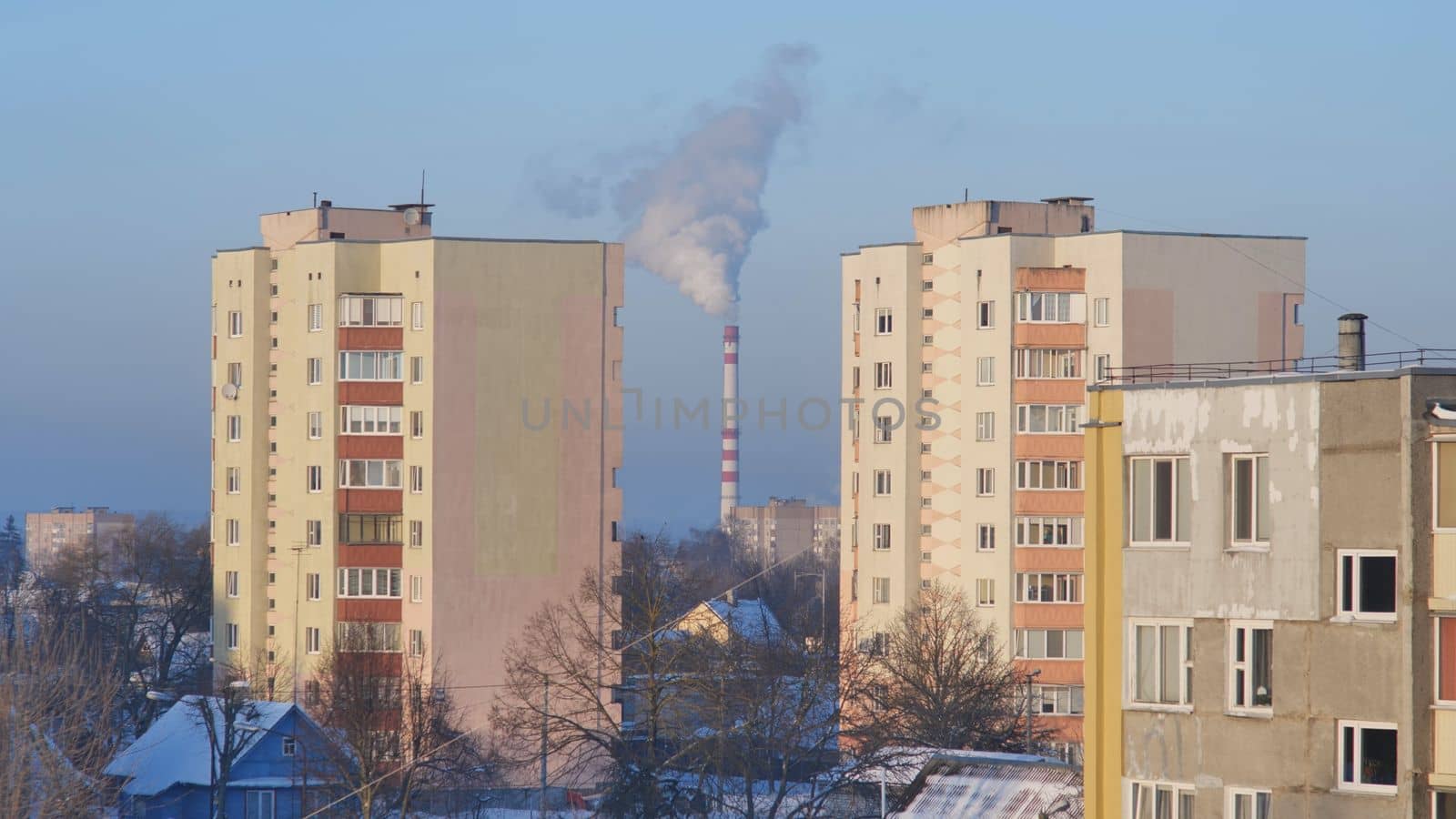 Houses of the residential area against the background of the smoky boiler house chimney
