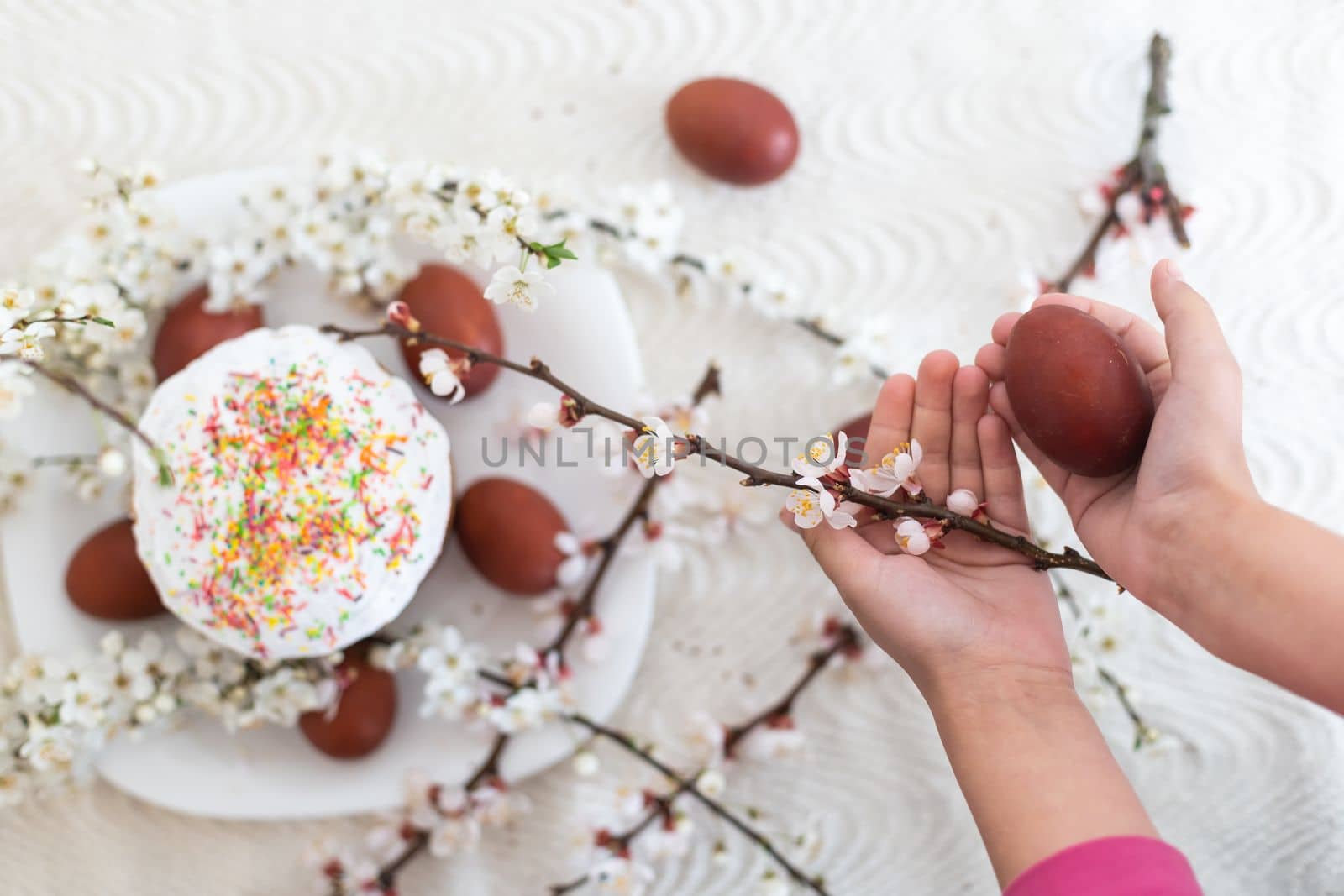 hands holding painted eggs. Easter cake.