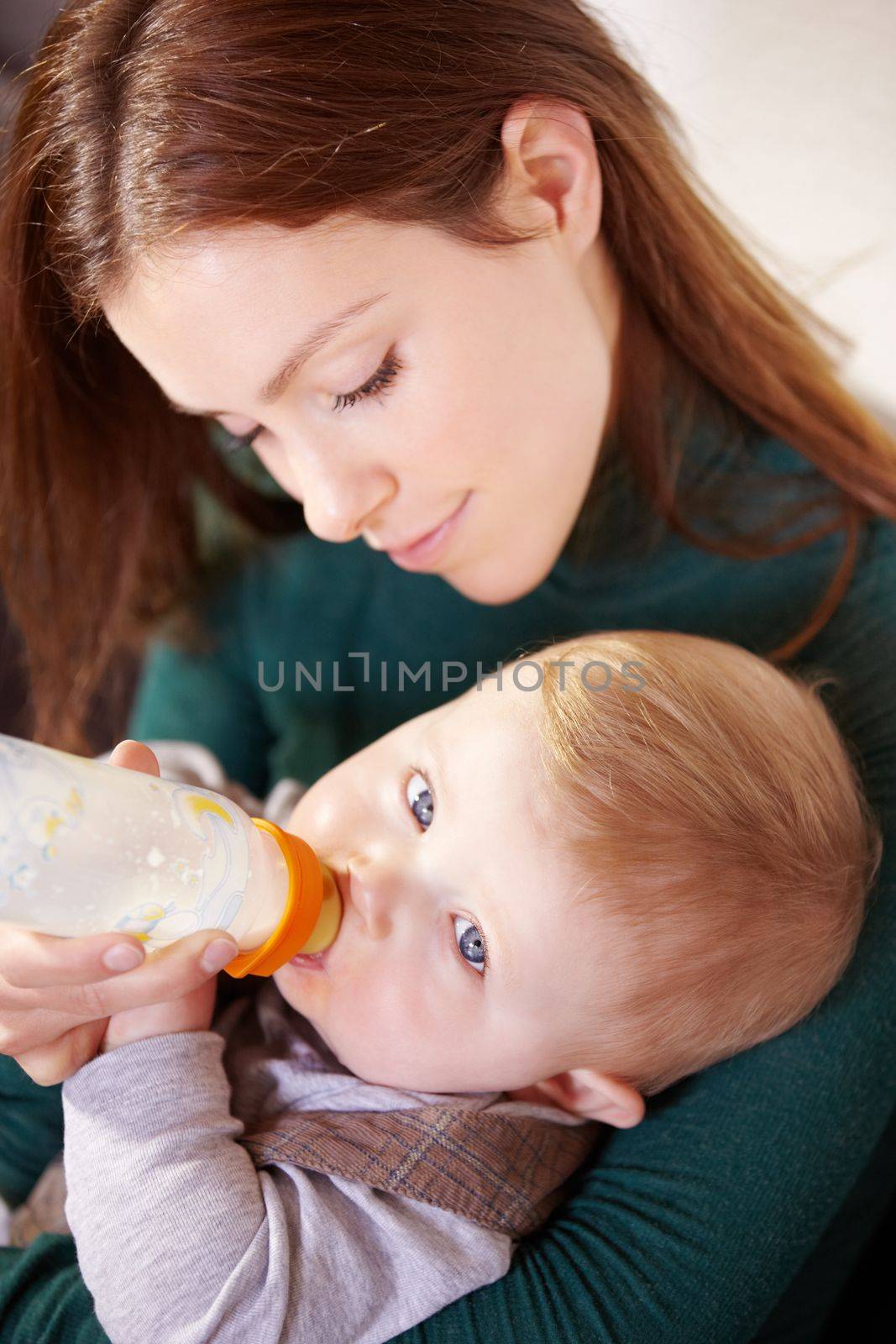 Getting all the nutrients he needs. Pretty young mother bottle-feeding her infant son