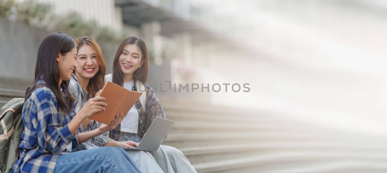 Beautiful young Asian woman college student with friends at outdoors. College student working on the college campus by itchaznong