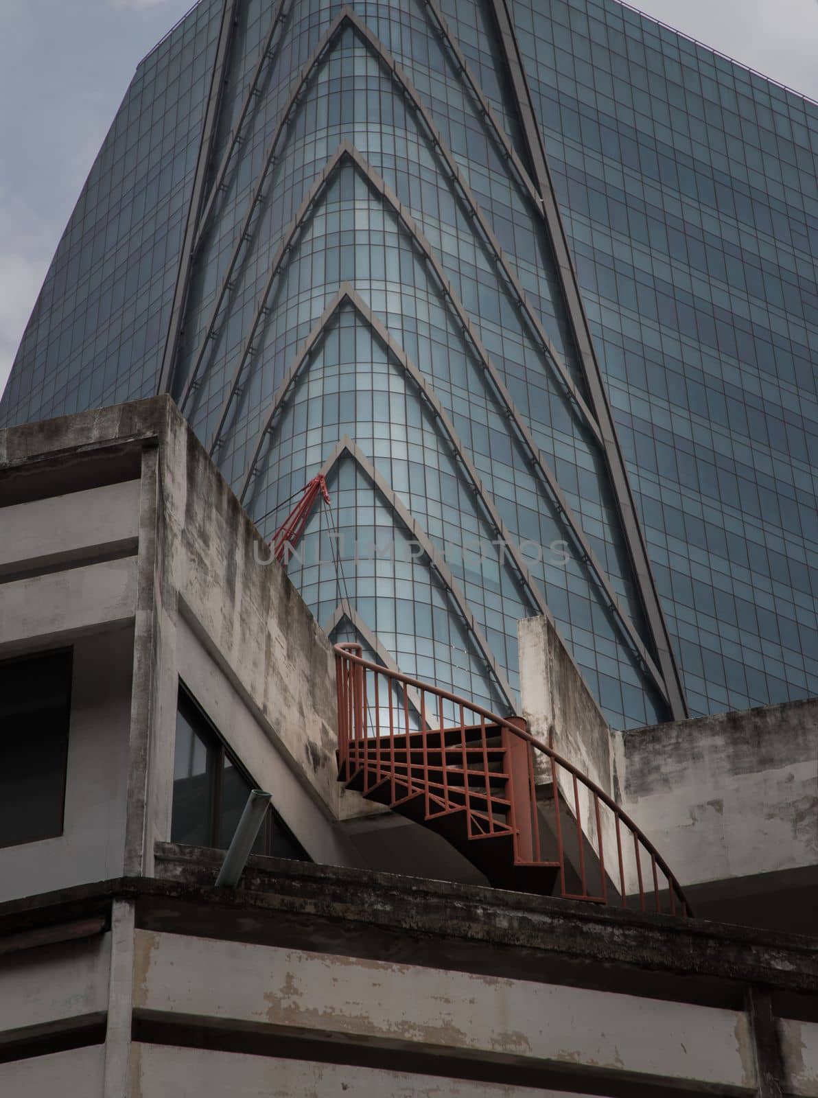 Bangkok, thailand - Mar 18, 2022 : Architectural View of Overlapping Modern high building exterior and Old house buildings with Red iron spiral staircase an points of interest. No focus, specifically.