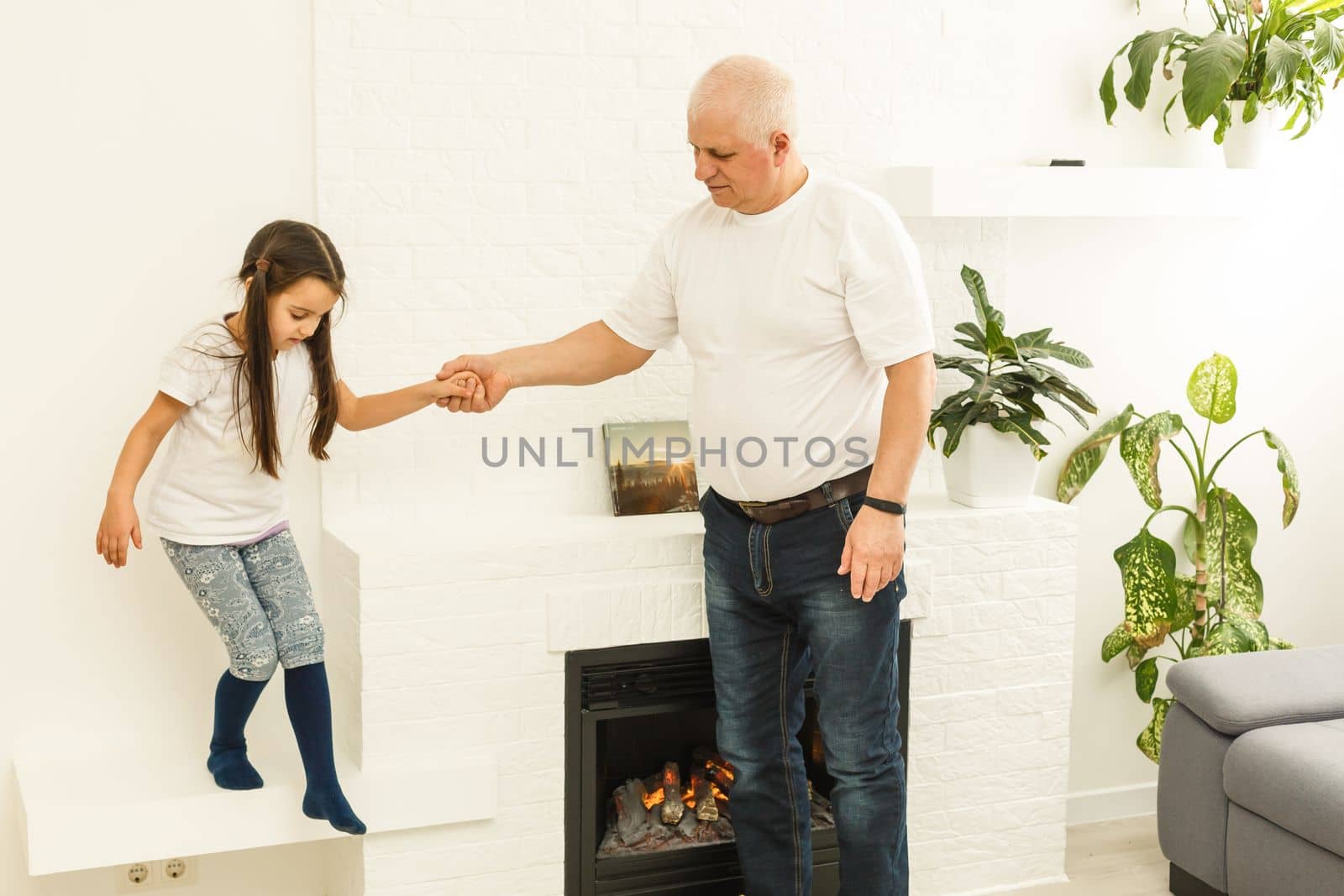 Little granddaughter hugging her grandfather