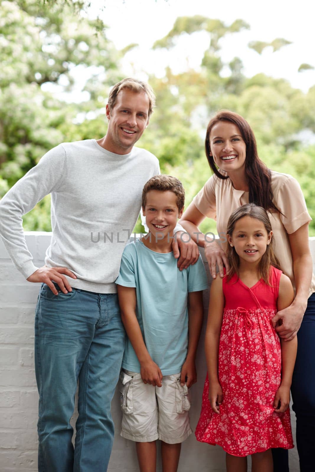 Quality family time. Portrait of a happy family of four standing together outside
