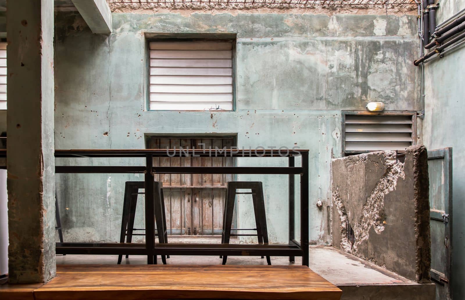 Interior design and decoration with table and two chairs at the background is the old concrete wall.  No focus, specifically.