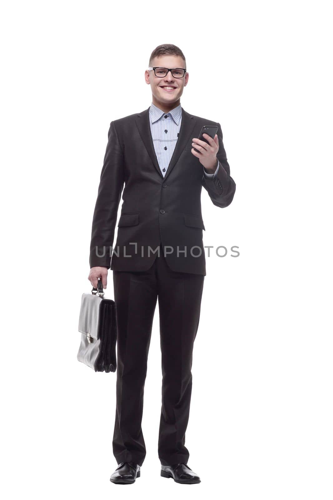 in full growth. responsible young businessman with a smartphone. isolated on a white background.
