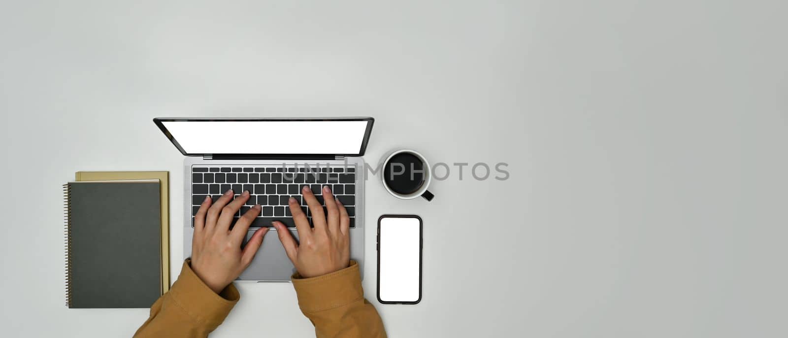 From above view of man hands typing on laptop computer over white background. Top view with copy space for advertise text.