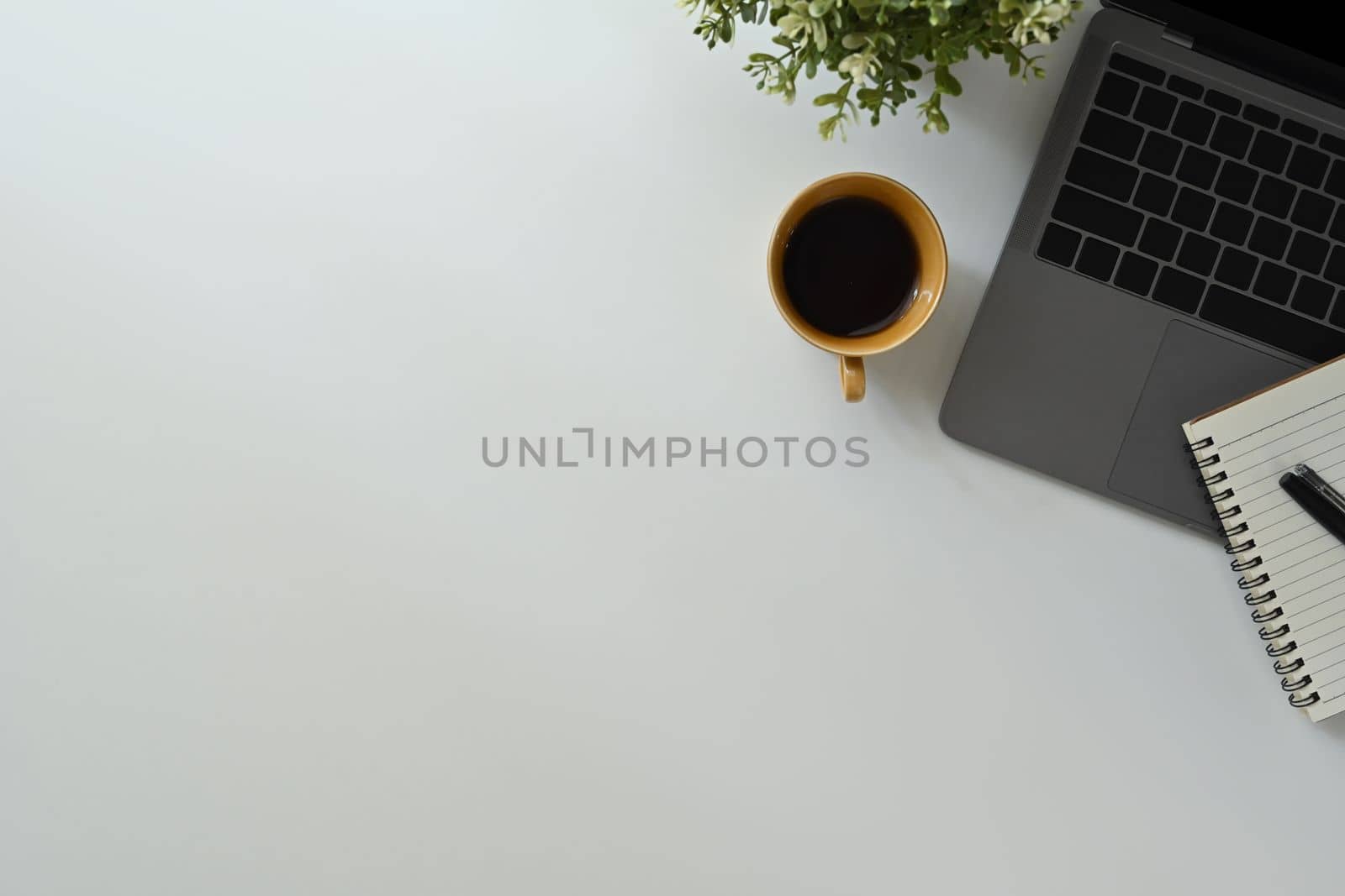 Laptop computer, cup of coffee and notebook on white office desk. Top view with copy space for your text by prathanchorruangsak