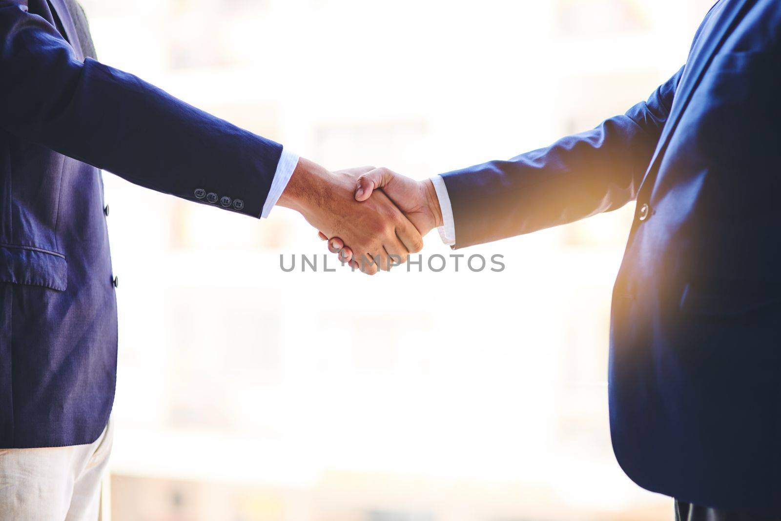 Forming strengthened business relationships. Closeup shot of two unidentifiable businesspeople shaking hands in an office. by YuriArcurs