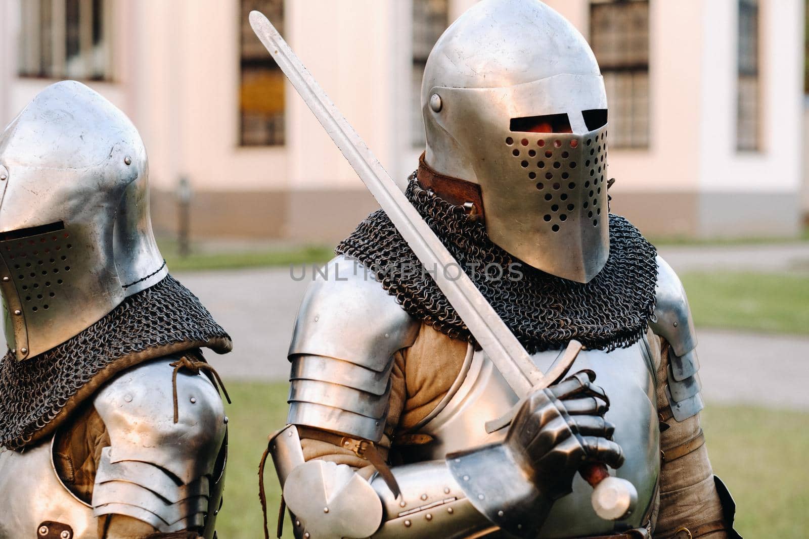 Two knights in armor on the background of a medieval castle.A medieval concept.Metallic texture.