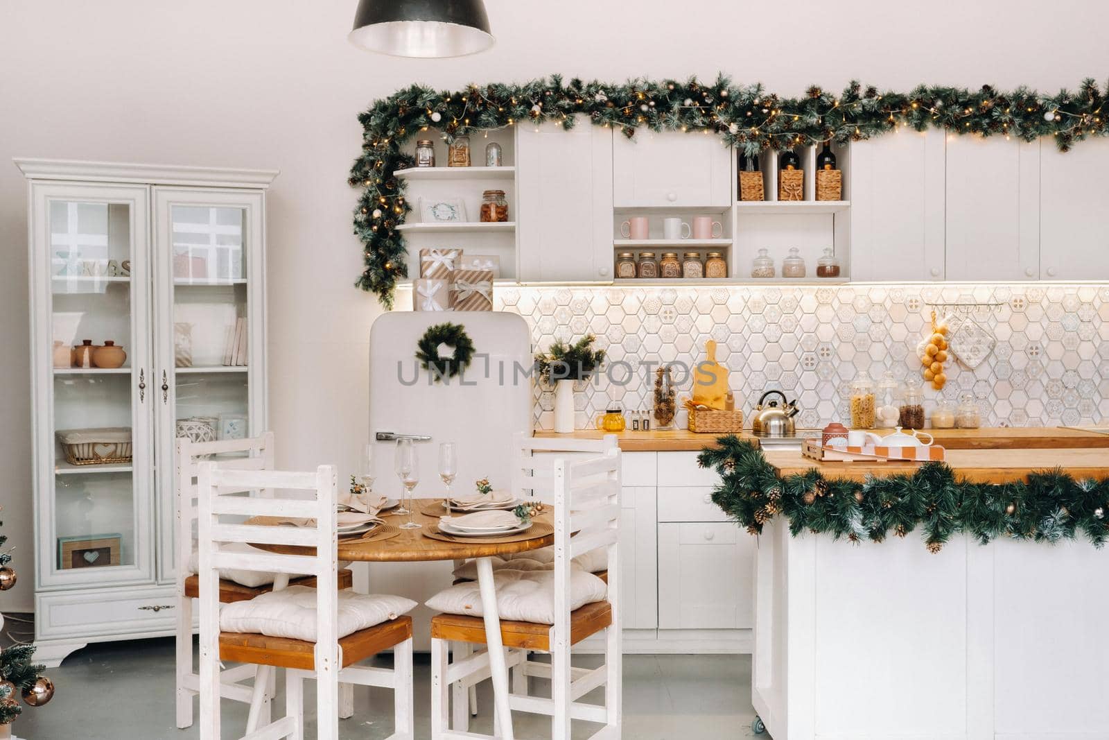 Christmas table decoration in the kitchen, Banquet table with glasses before serving food, close-up of the Christmas dinner table with seasonal decorations, crystal glasses and decorative deer.