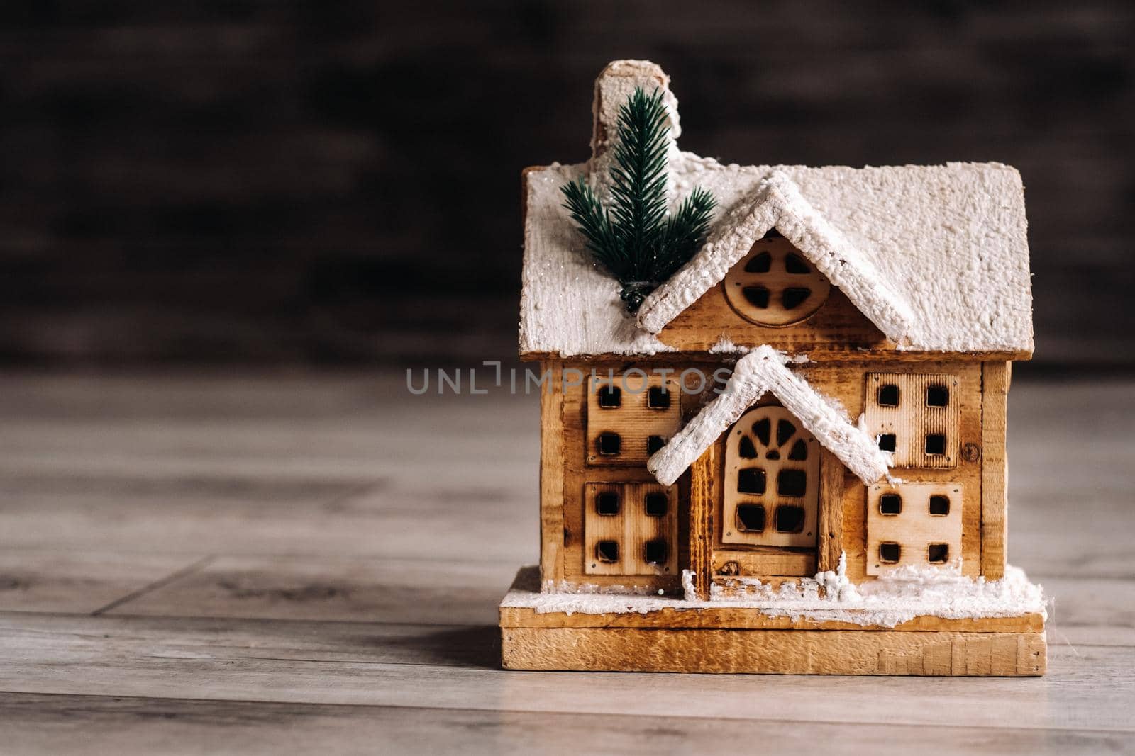 small snow-covered Christmas house on the floor of the house.Winter house decorative by Lobachad