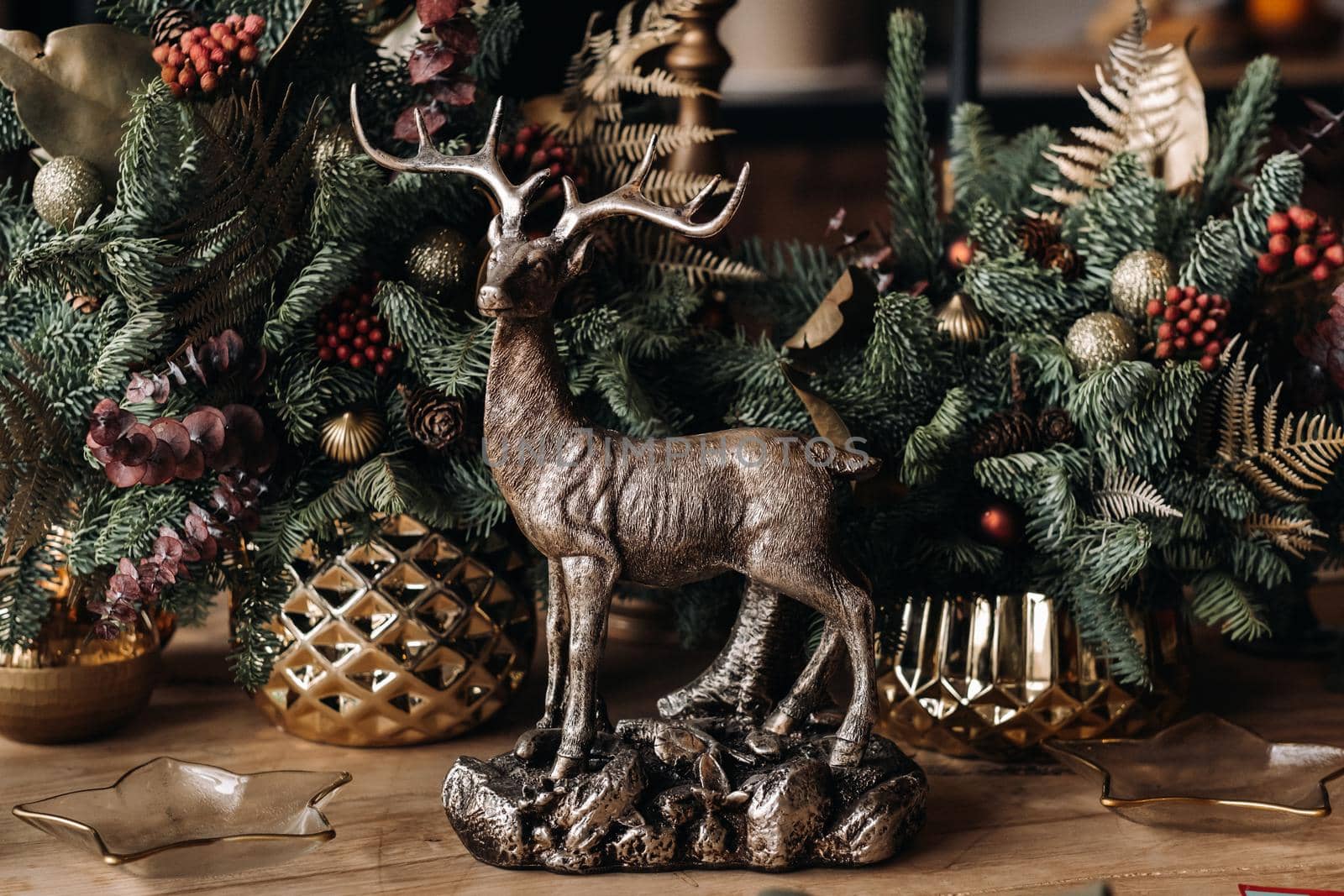 Christmas table decoration, Banquet table with glasses before serving food, Close-up of Christmas dinner table with seasonal decorations, crystal glasses and decorative deer by Lobachad