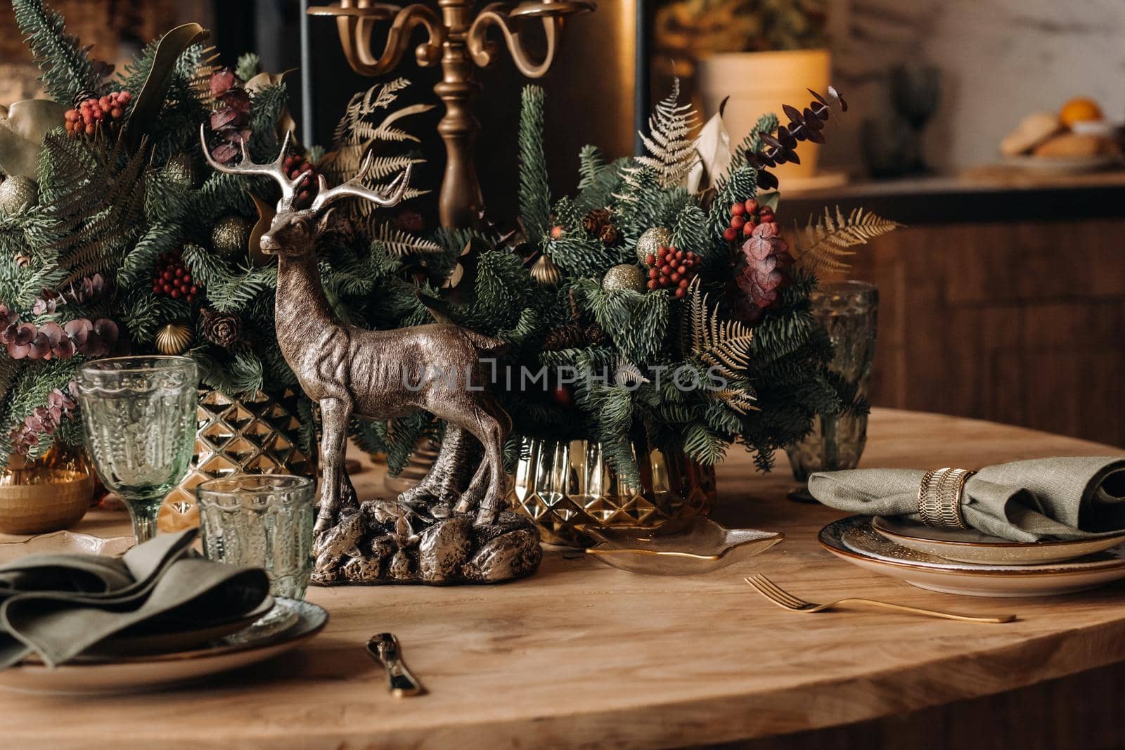 Christmas table decoration, Banquet table with glasses before serving food, Close-up of Christmas dinner table with seasonal decorations, crystal glasses and decorative deer.