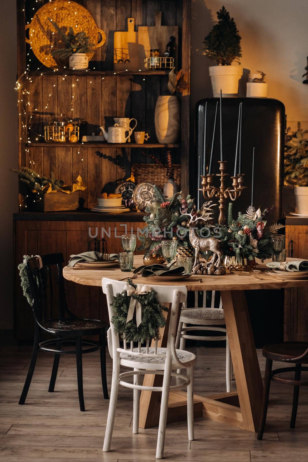 Christmas table decoration, Banquet table with glasses before serving food, Close-up of Christmas dinner table with seasonal decorations, crystal glasses and decorative deer.