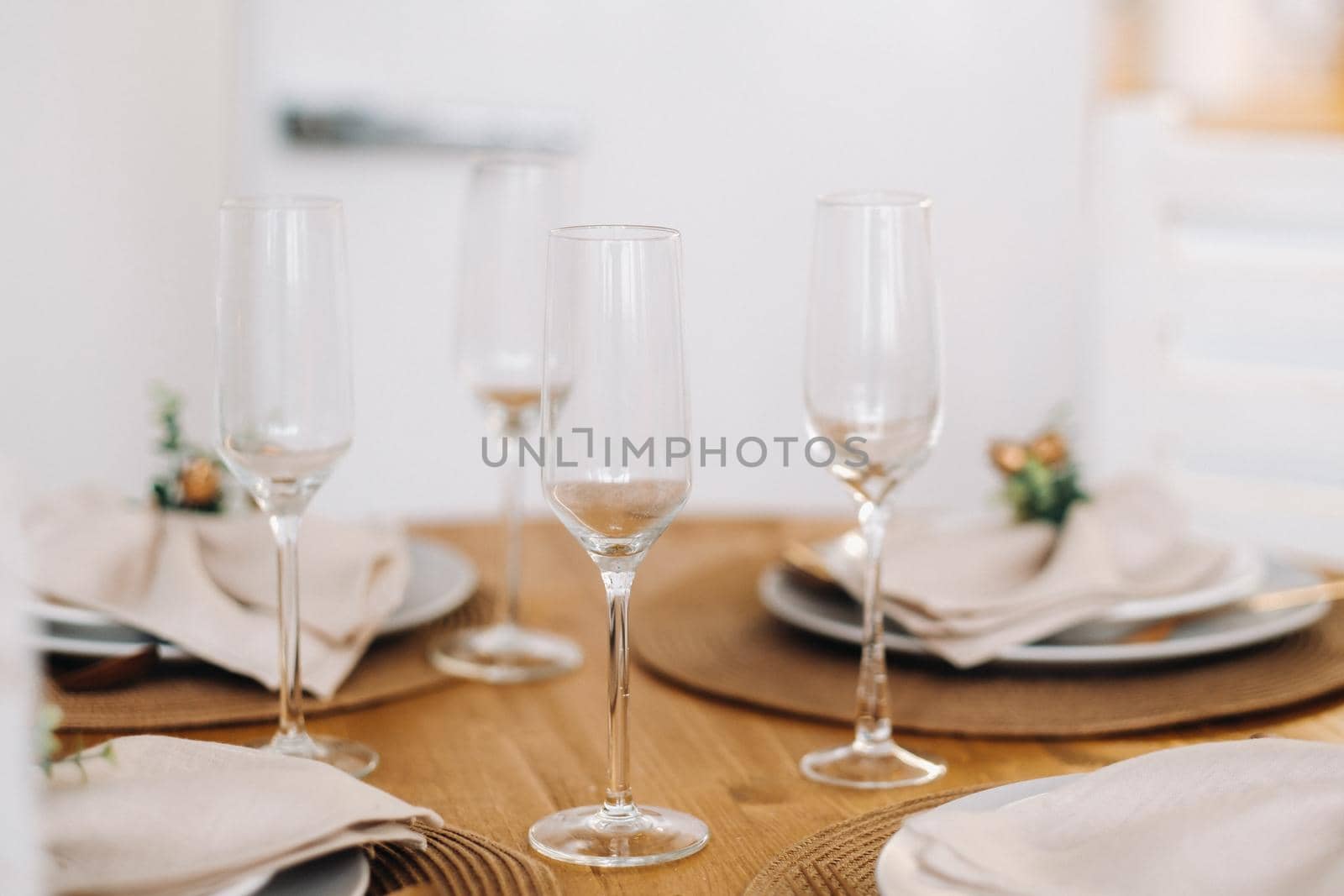 champagne glasses on the decorated Christmas table, crystal glasses at the table by Lobachad