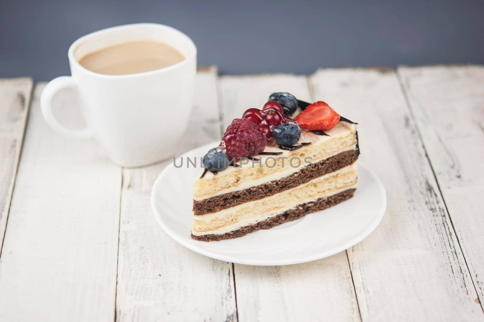 Mix berry slice cake on white plate on wood background