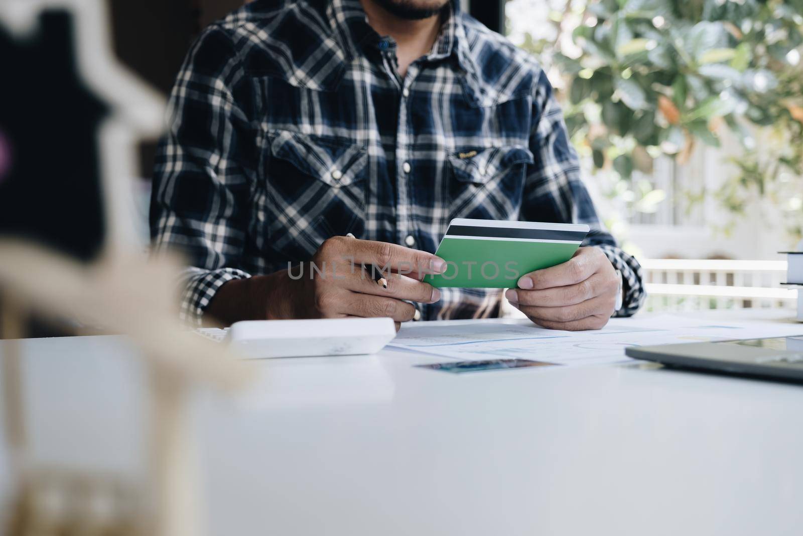 A man with a savings account calculates the amount of money he can save this year. Real Estate and account or saving money or insurance concept. by itchaznong