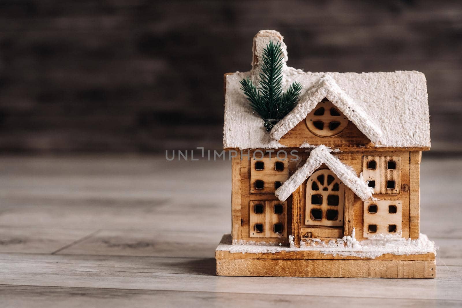 small snow-covered Christmas house on the floor of the house.Winter house decorative.