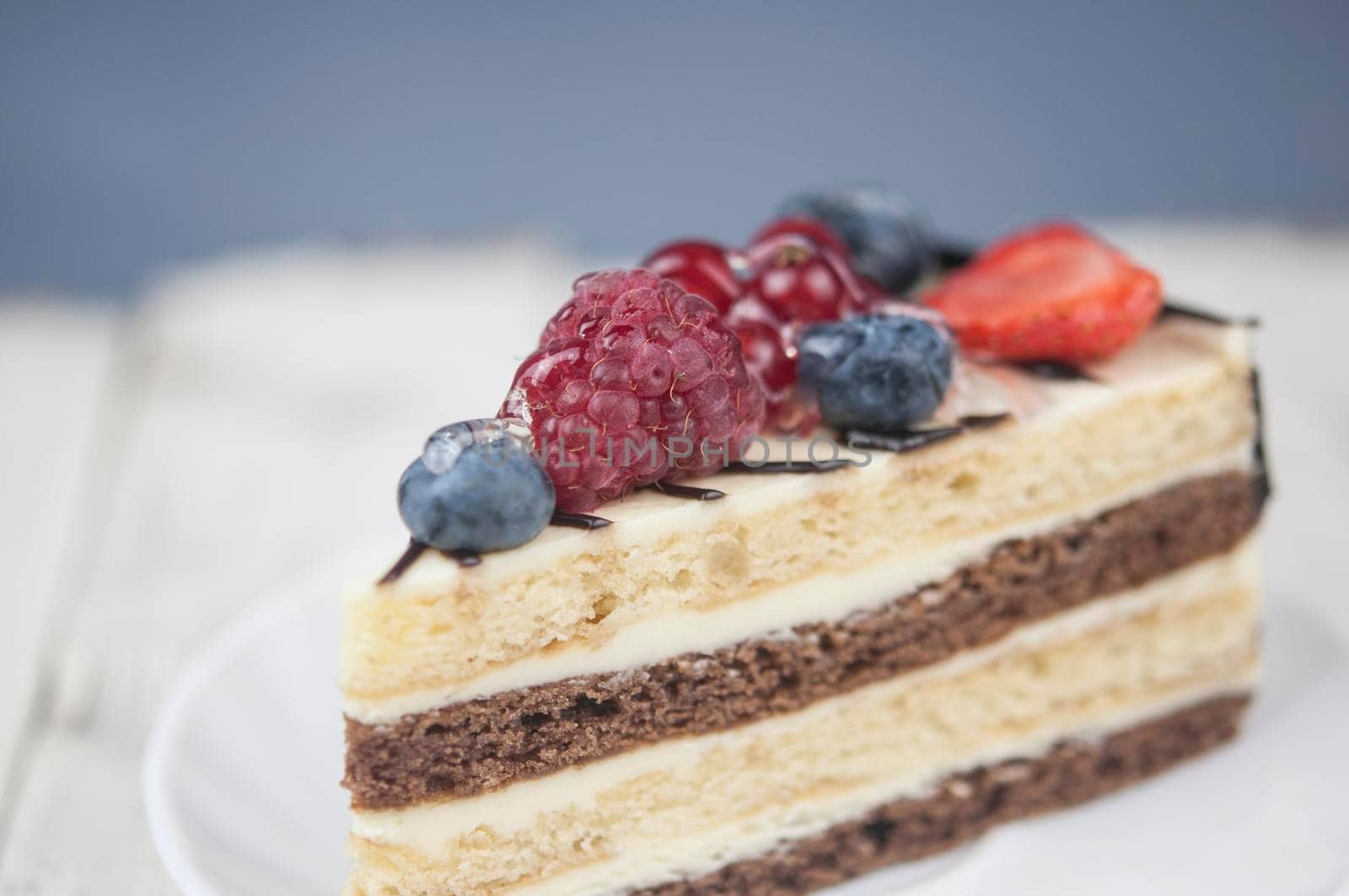 Mix berry slice cake on white plate on wood background