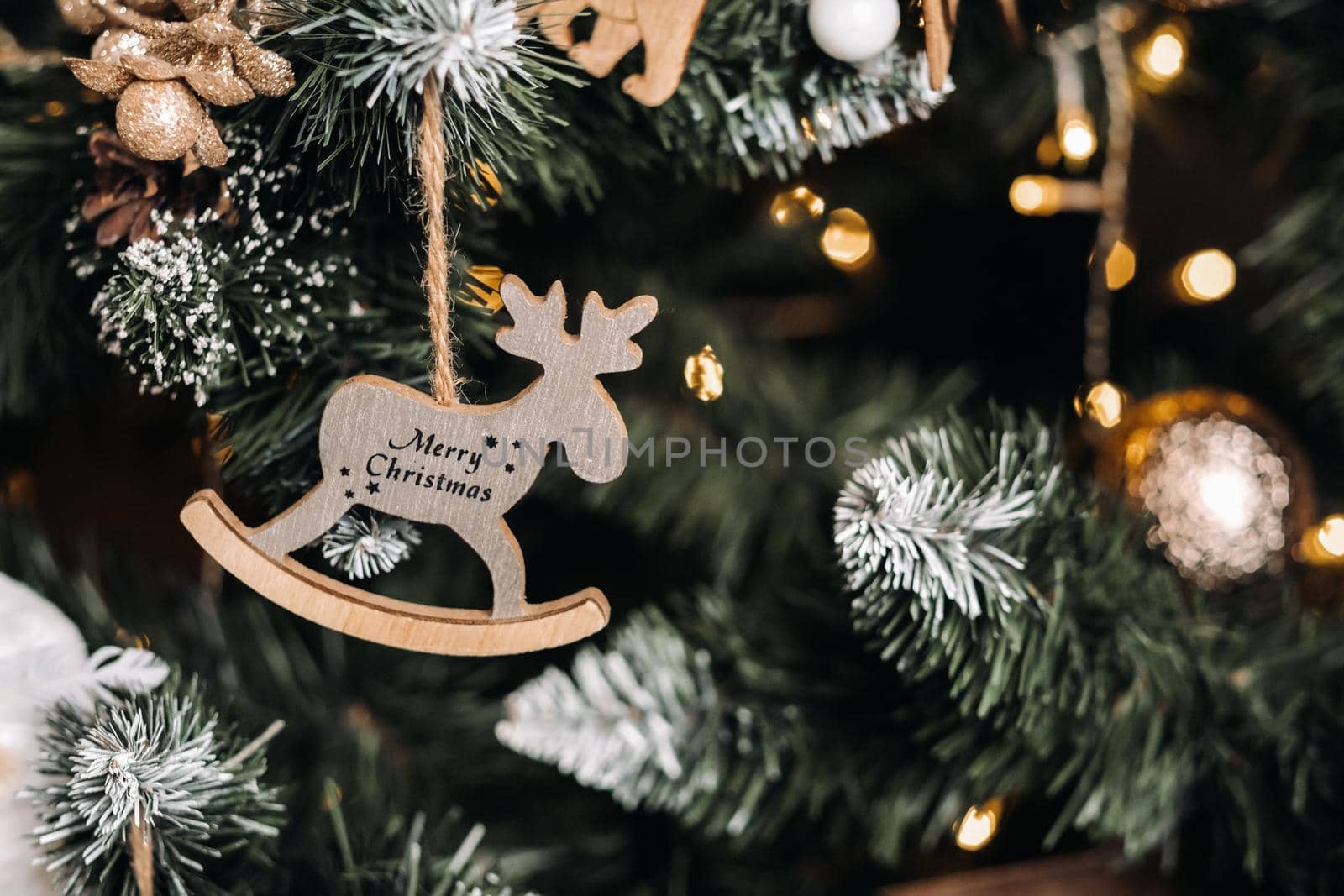 Christmas tree close-up with a hanging deer and the inscription merry Christmas.