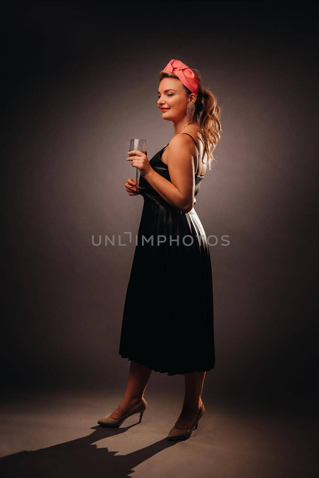 a woman in a black dress holding a glass of champagne on a black background, Christmas, holiday by Lobachad