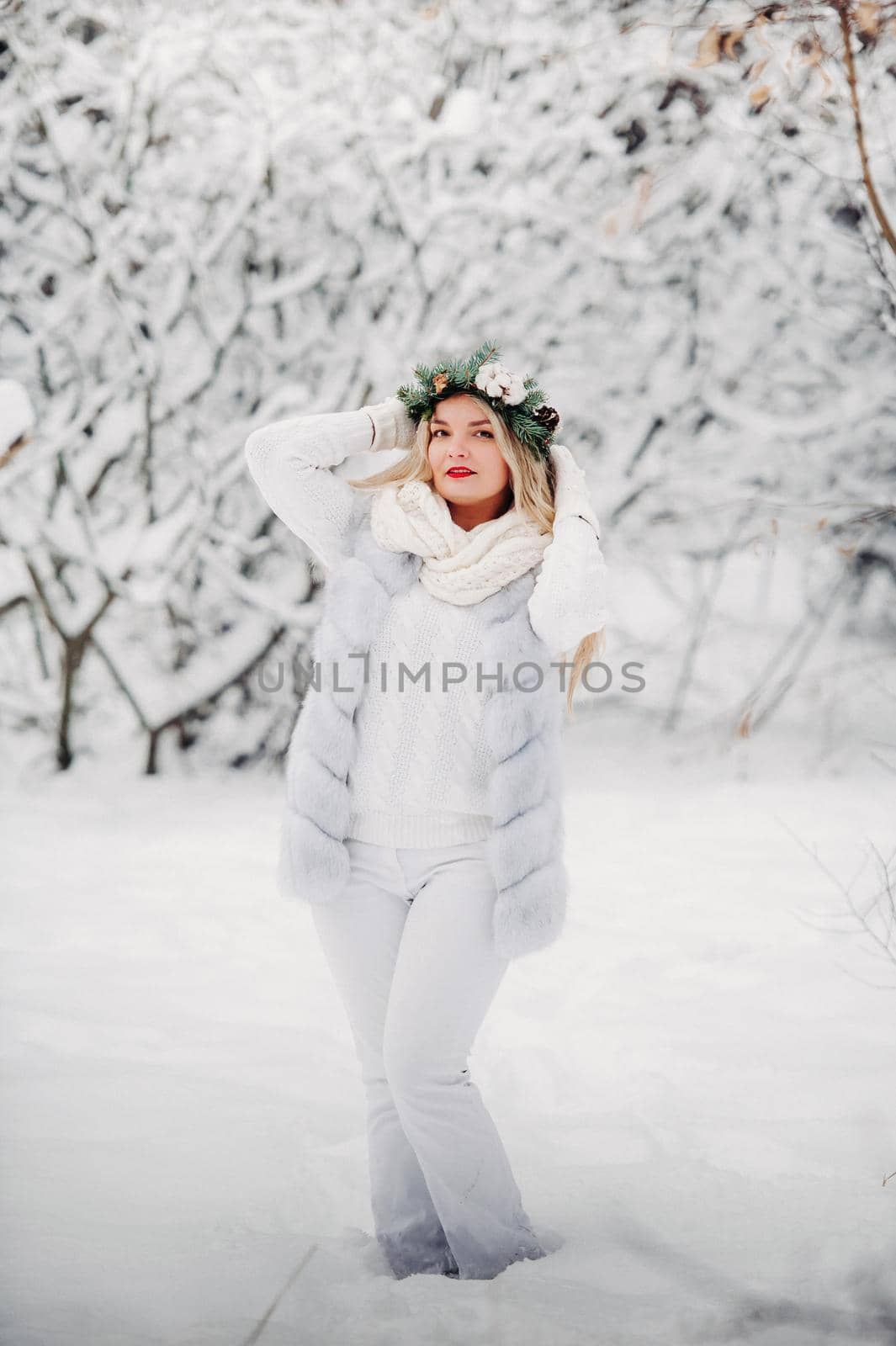 Portrait of a woman in white clothes in a cold winter forest. Girl with a wreath on her head in a snow-covered winter forest by Lobachad