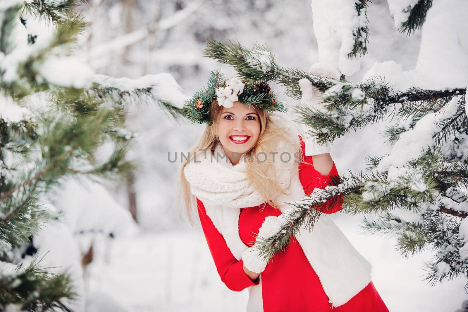 Portrait of a woman in a red jacket in a cold winter forest. Girl with a wreath on her head in a snow-covered winter forest by Lobachad