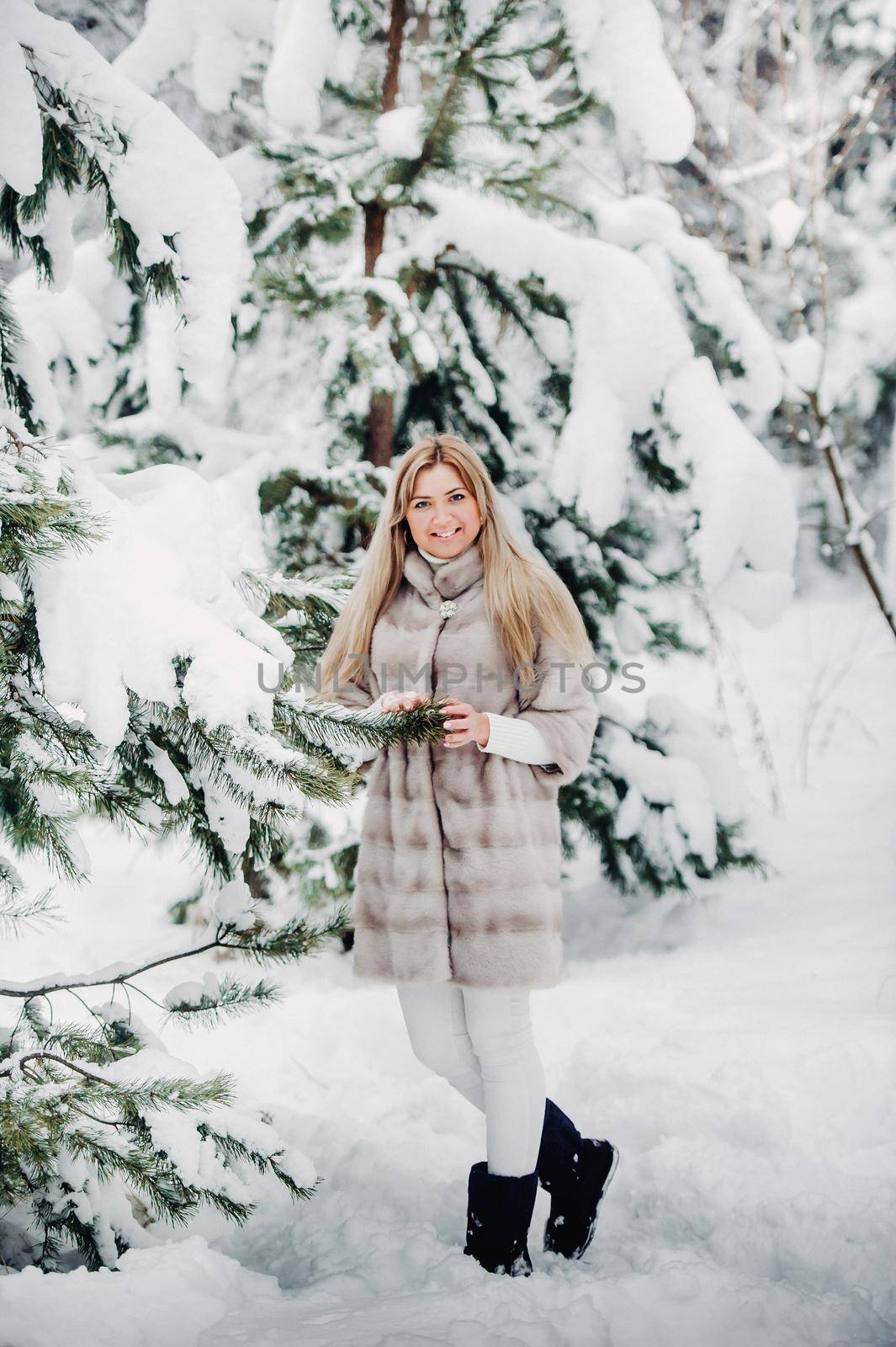 Portrait of a woman in a white fur coat in a cold winter forest. Girl in a snow-covered winter forest by Lobachad