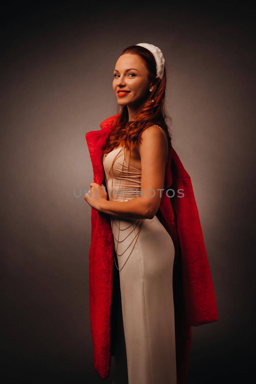 a woman in a white dress and a red fur coat with a white Hoop on a black isolated background. Stylish portrait of a girl with the colors of the Latvian flag