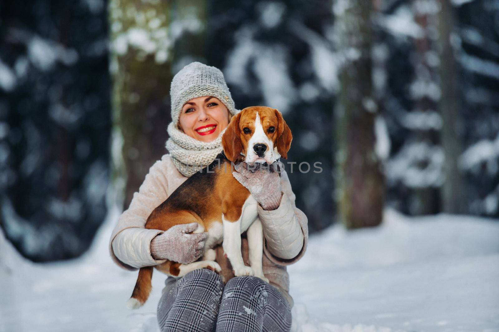 a woman on a walk with her dog in the winter forest. mistress and dog game in the snowy forest.