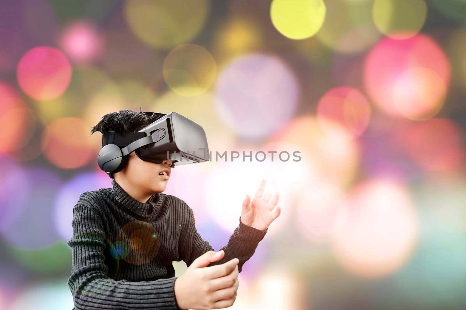 Asian teenage wearing VR glasses headset with colorful blurred bokeh background, use for using technology and futuristic concepts.