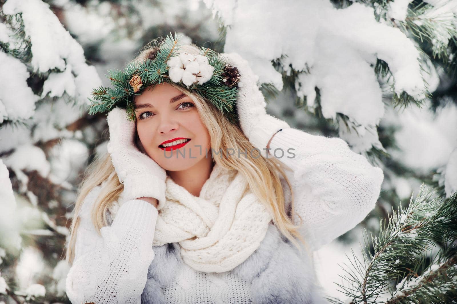 Portrait of a woman in white clothes in a cold winter forest. Girl with a wreath on her head in a snow-covered winter forest by Lobachad