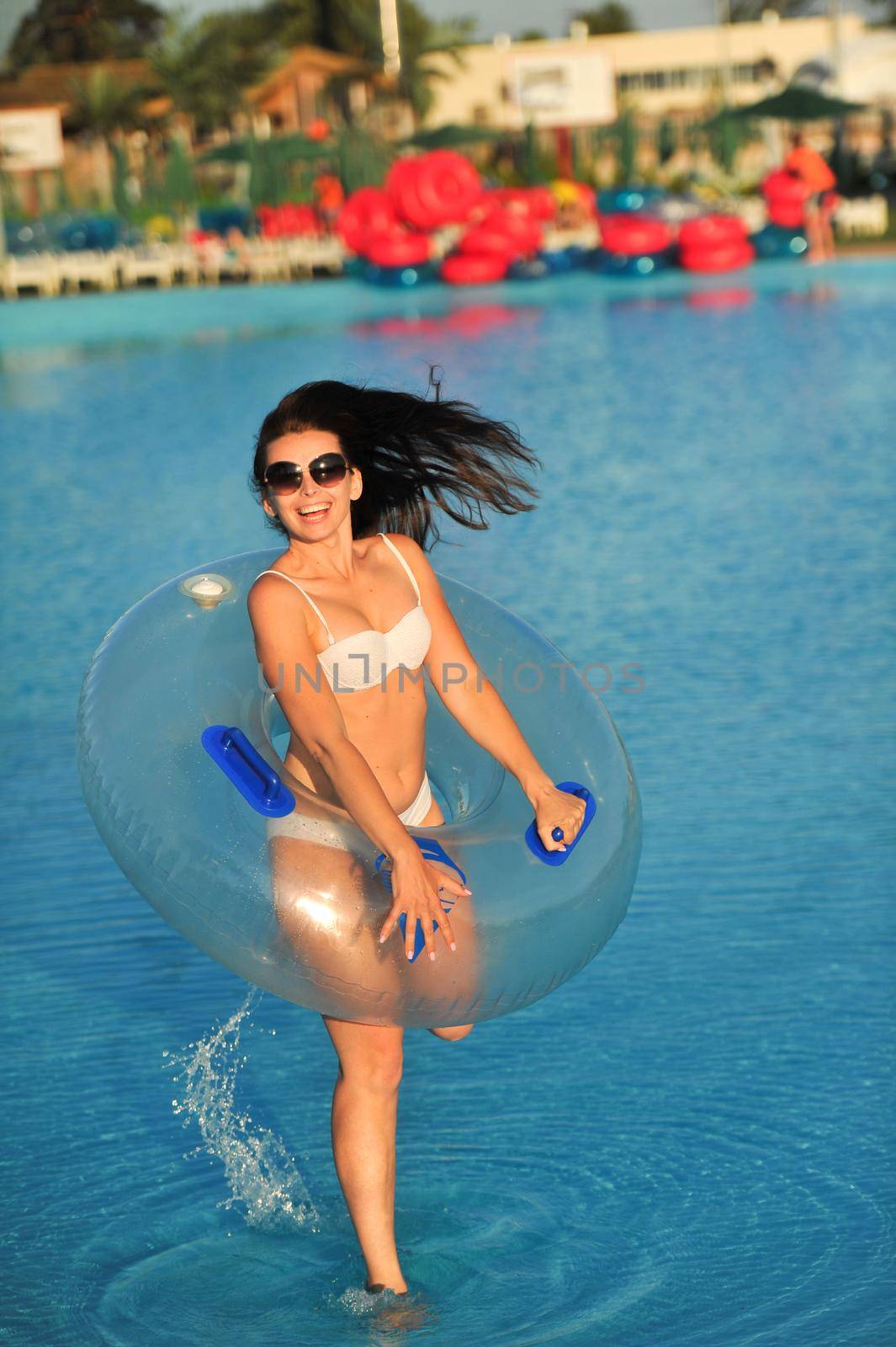 A woman in a white bathing suit with an inflatable circle in a water Park by Lobachad