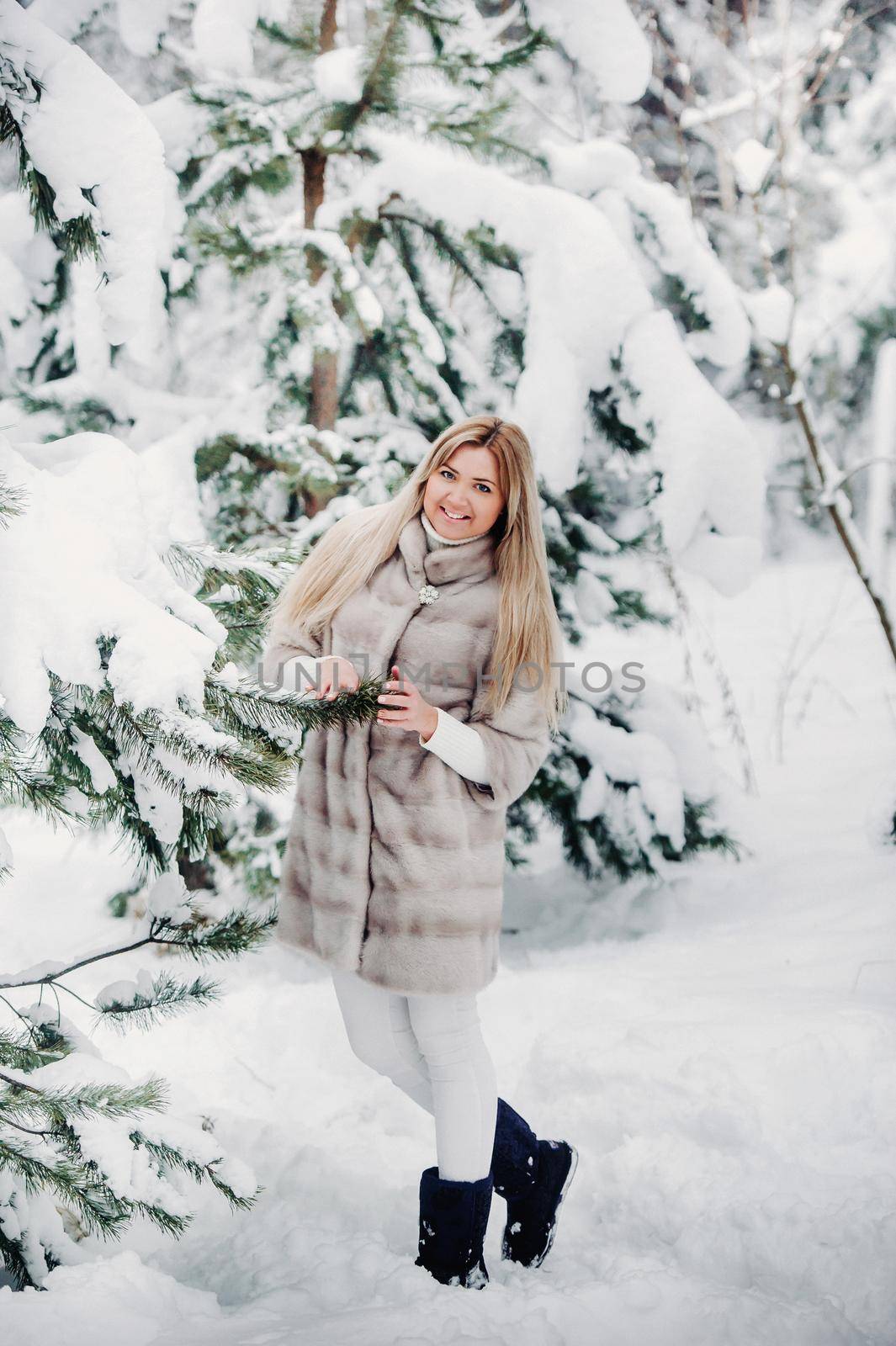 Portrait of a woman in a white fur coat in a cold winter forest. Girl in a snow-covered winter forest by Lobachad