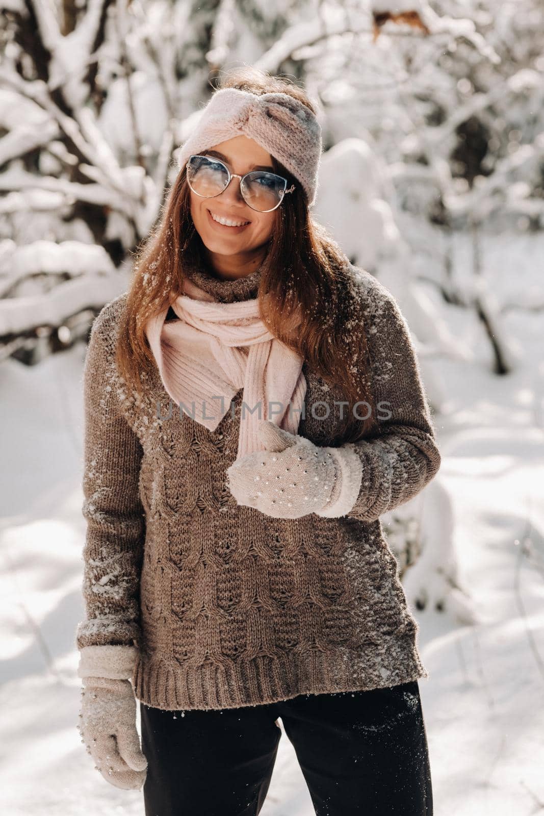 A girl in a sweater and glasses in winter in a snow-covered forest by Lobachad