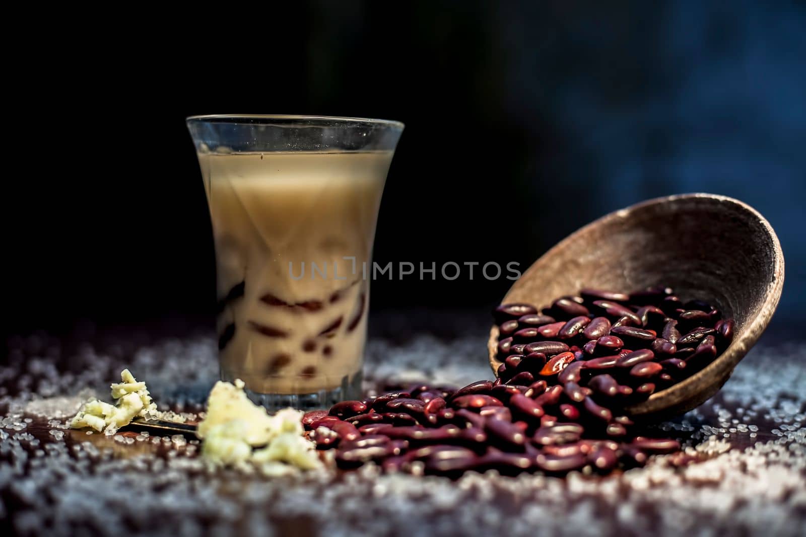 Red bean bubble tea in a glass along with some raw kidney beans, butter and sugar on the brown surface with Rembrandt light technique. Horizontal shot. by mirzamlk