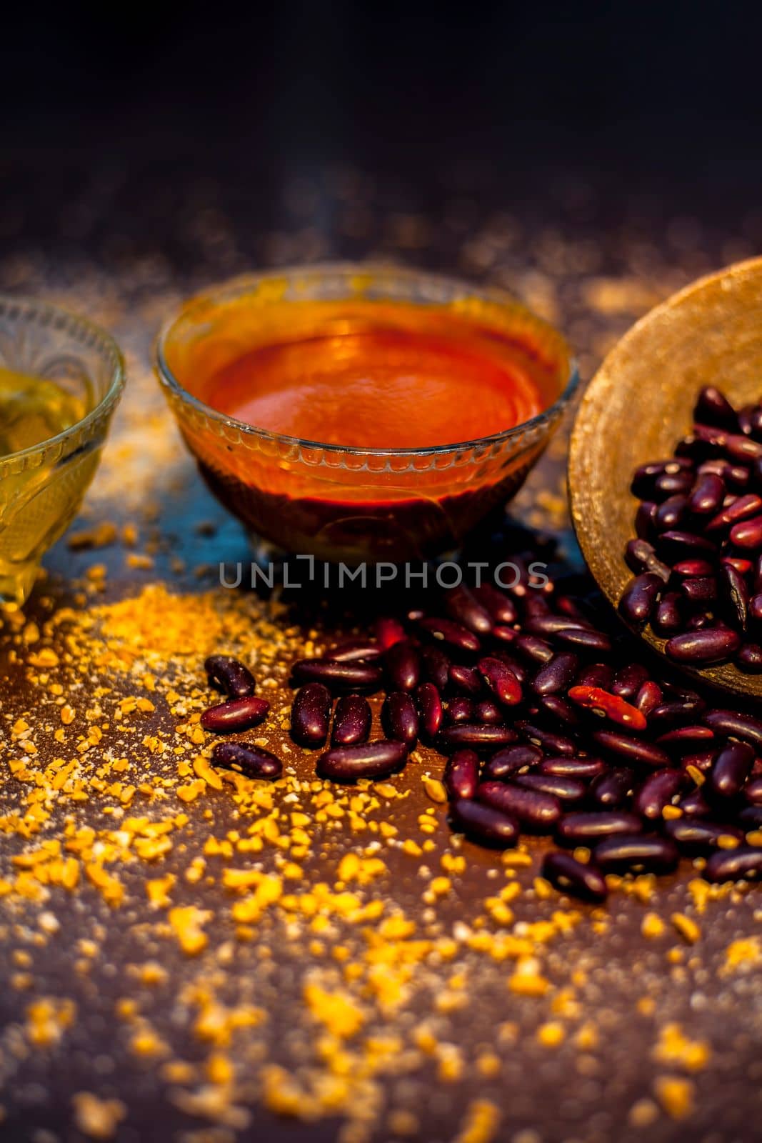 Home pore remedy on the black glossy surface consisting of some red beans or kidney beans mung beans and some green tea. Well mixed together in a bowl. Face mask for pore prevention.Vertical shot. by mirzamlk