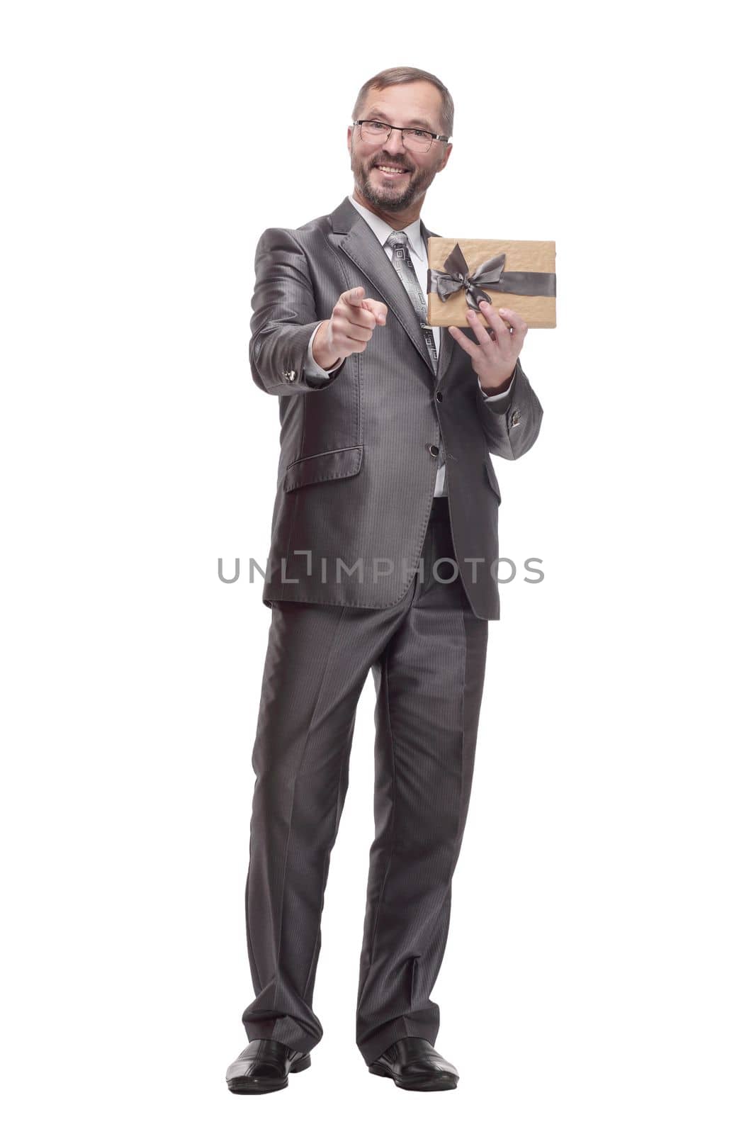in full growth.happy business man with a gift box. isolated on a white background.