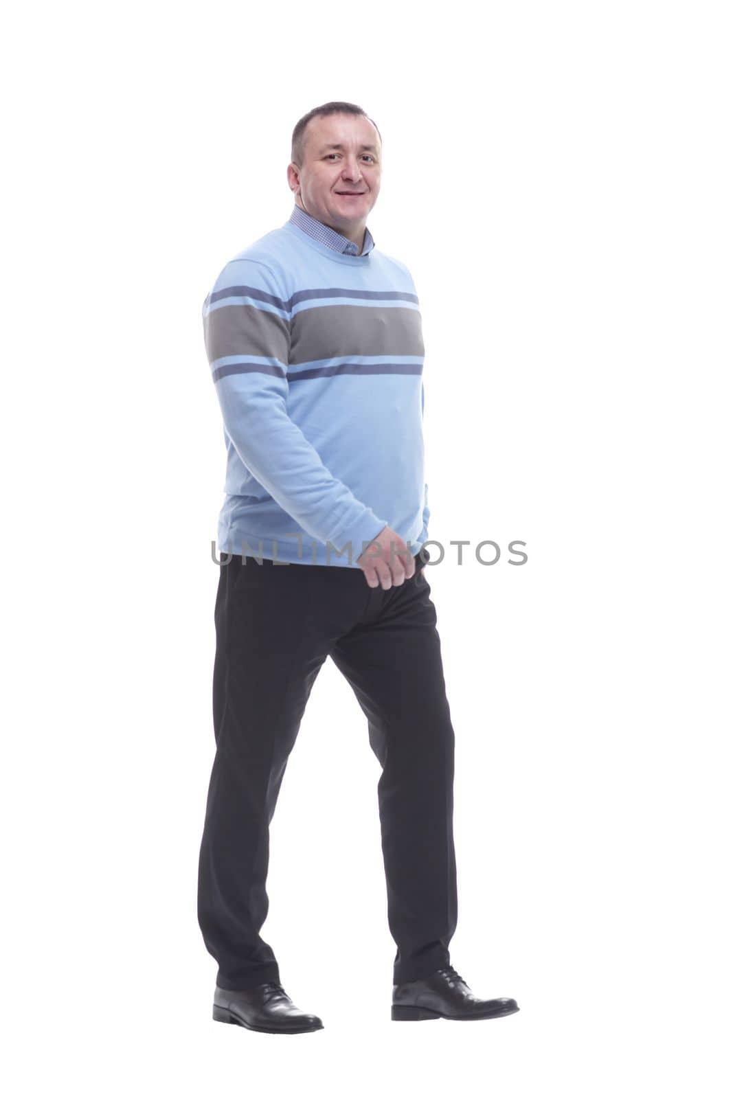 side view. a serious man in a sweater walks forward by asdf