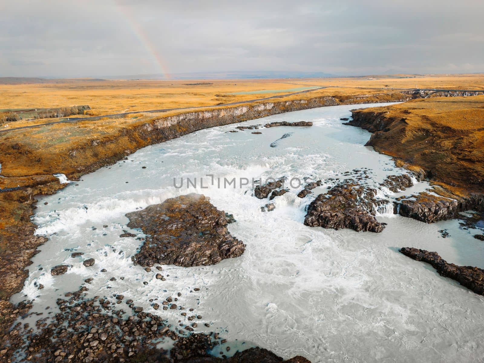 Bright blue river trough Iceland mainland in autumn time on a cold cloudy day. High quality photo