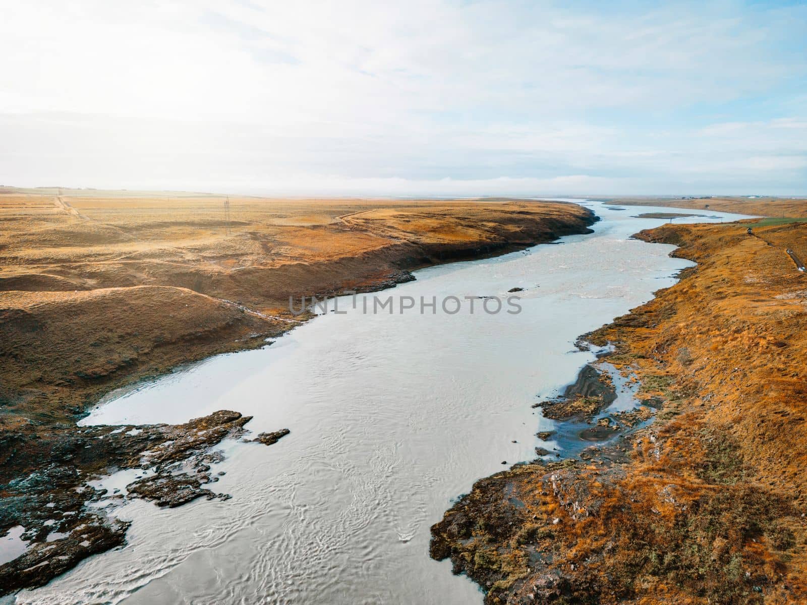 Bright blue river trough Iceland mainland in autumn time on a cold day. High quality photo