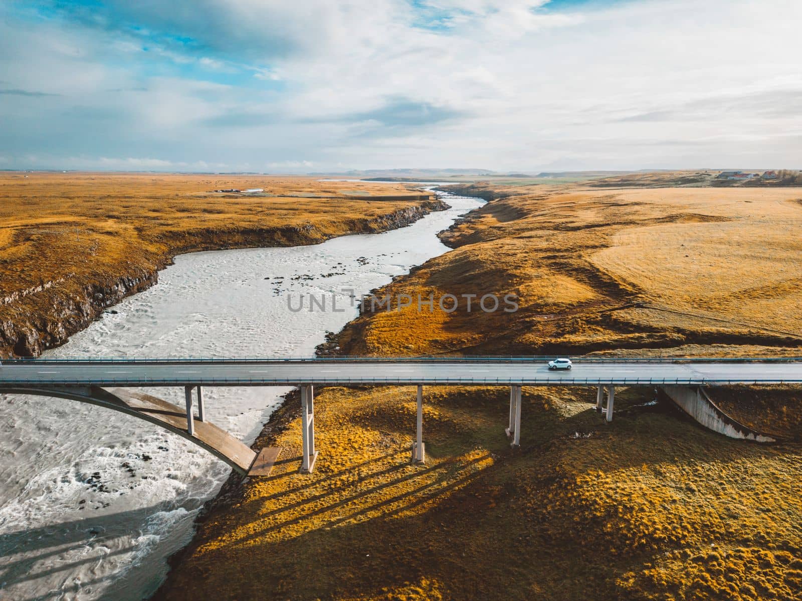 Bright blue river under the bridge trough Iceland mainland in autumn time on a cold day. High quality photo