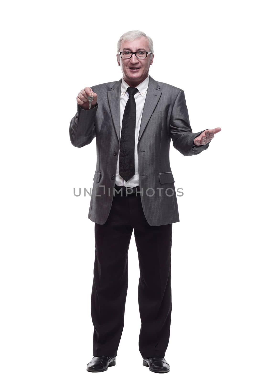 in full growth. business man with keys in hand. isolated on a white background.