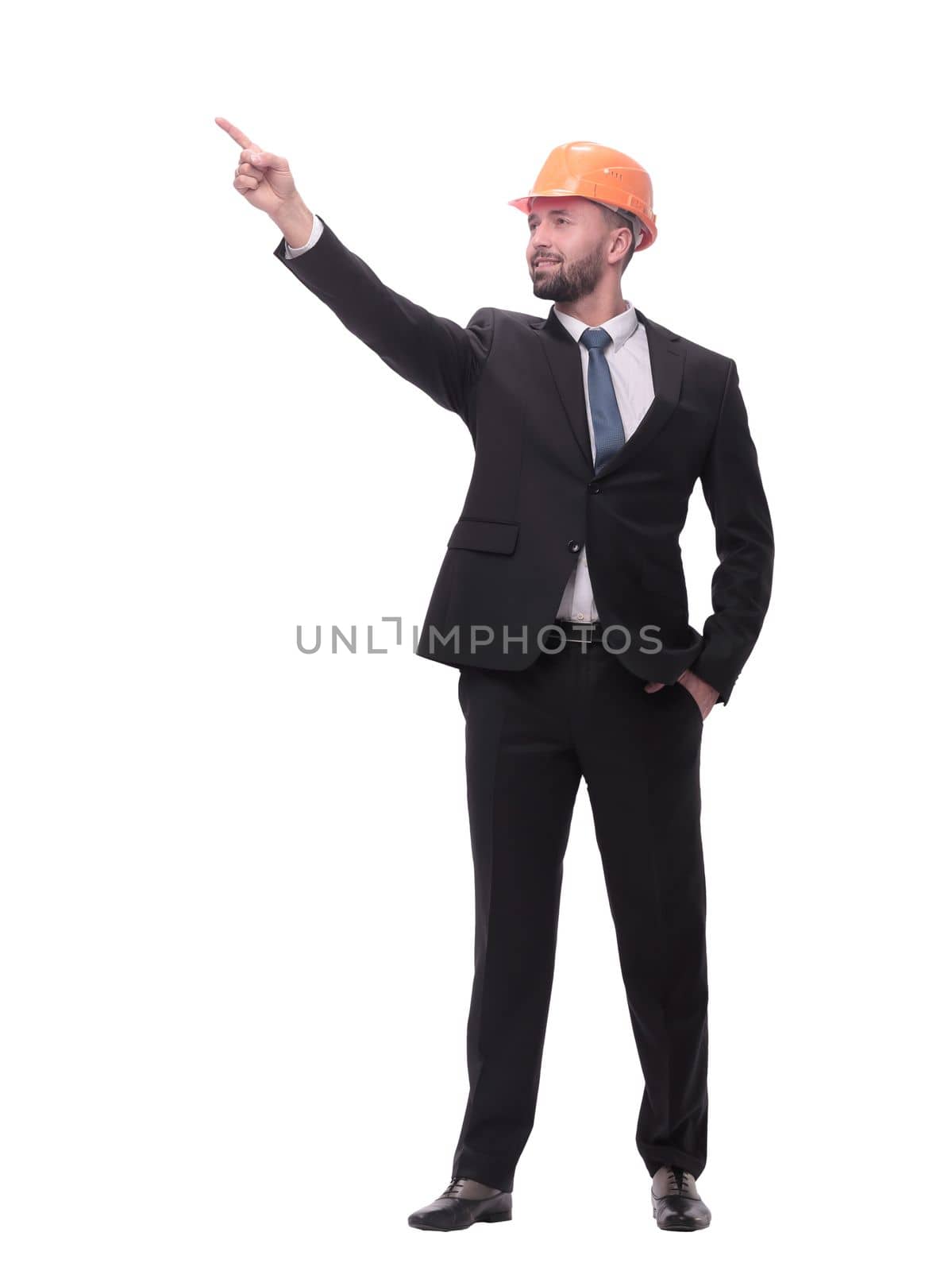 in full growth. young businessman in helmet pointing to copy space. isolated on white