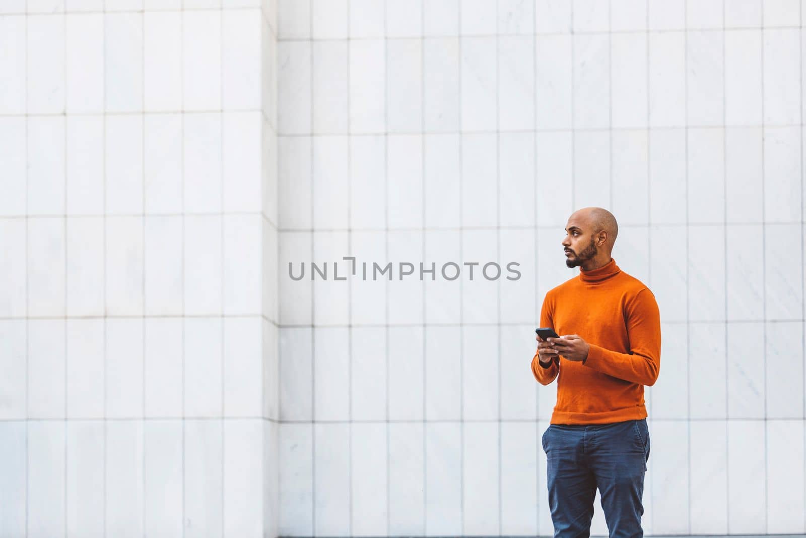 Man holding a phone standing outside the office building by VisualProductions