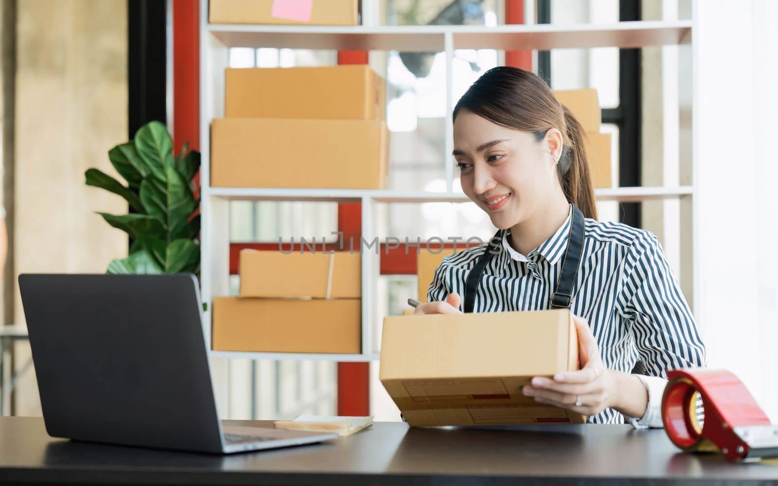 Asian girl working with boxes at home office small business owner start up Entrepreneur, small business, SME or self-employed online and delivery concept by nateemee