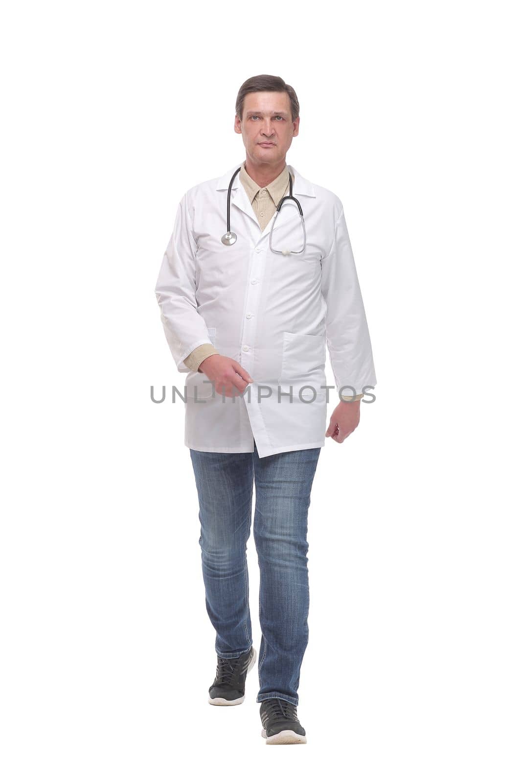 Full length portrait of young caucasian with stethoscope walking doctor isolated on white
