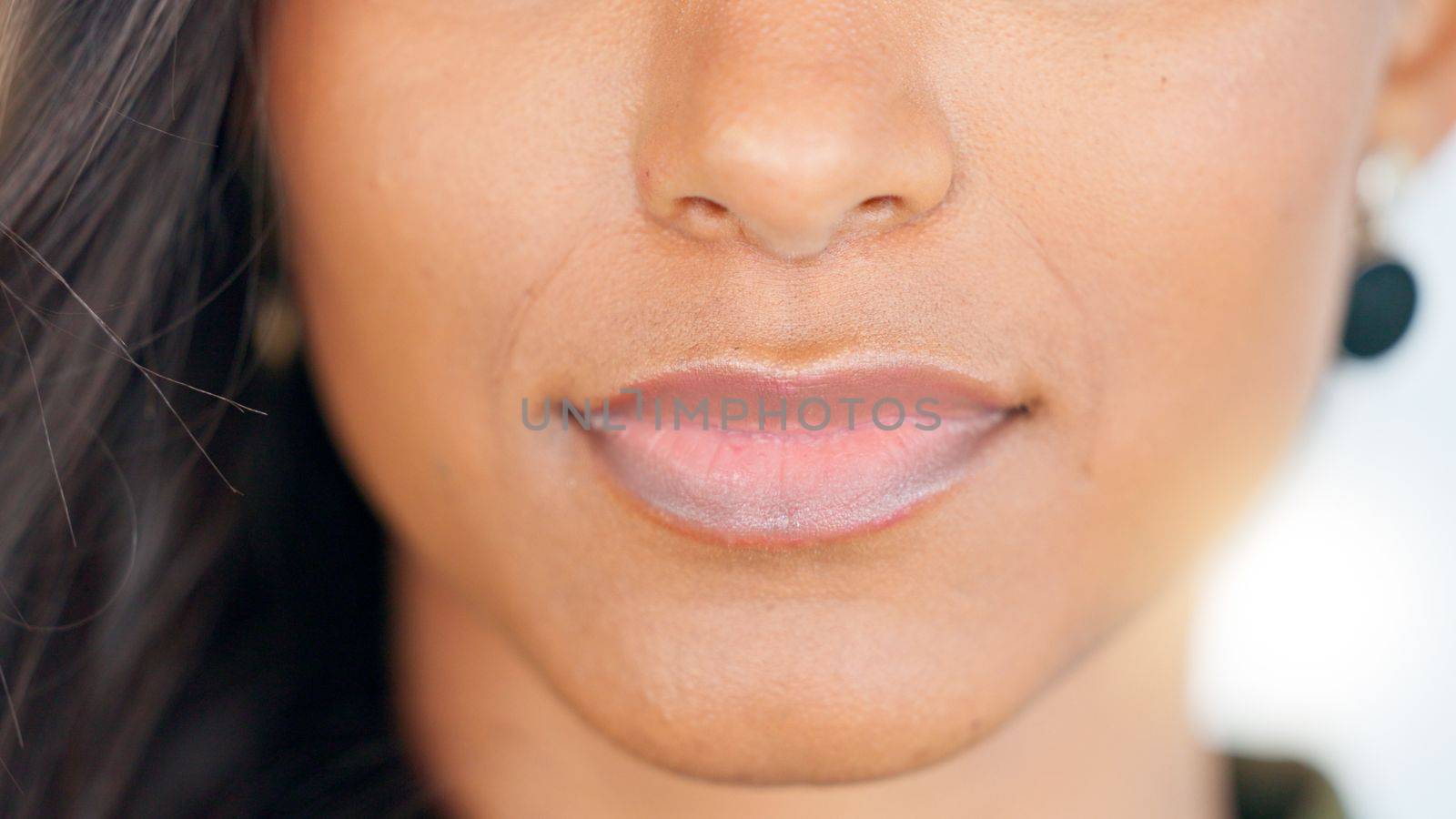 Smiling, beautiful and fresh female face winking feeling fun, silly and playful. Portrait of a happy woman head with perfect skin and healthy teeth. Closeup of a carefree natural beauty with a smile.