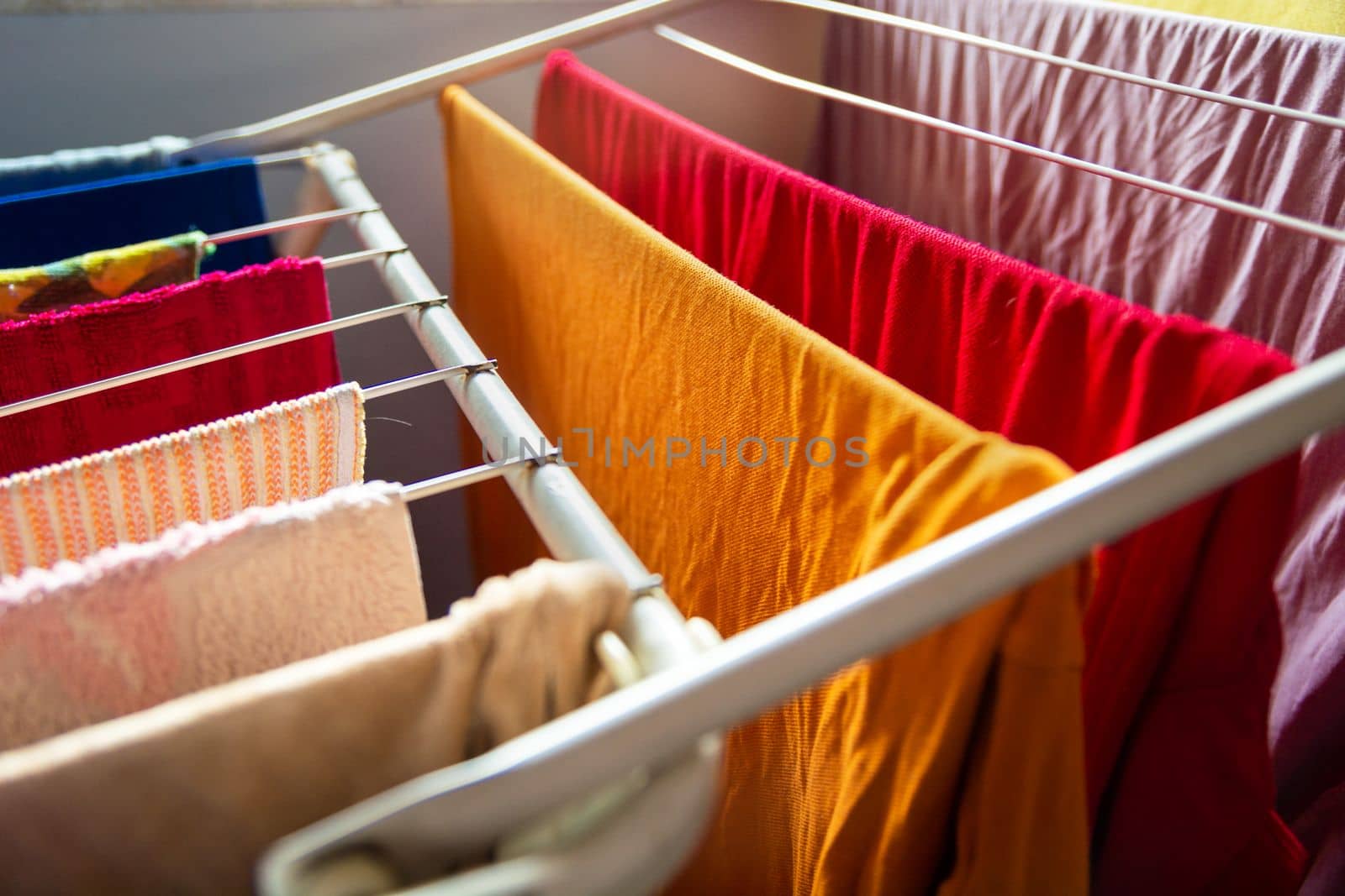 Close-up of washed colorful clothes hanging on the dryer